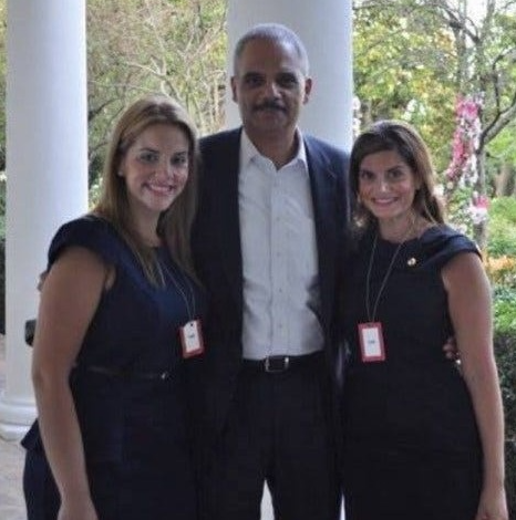Eric Holder outside the Oval Office in 2016 with two unidentified women in blue dresses, probably interns