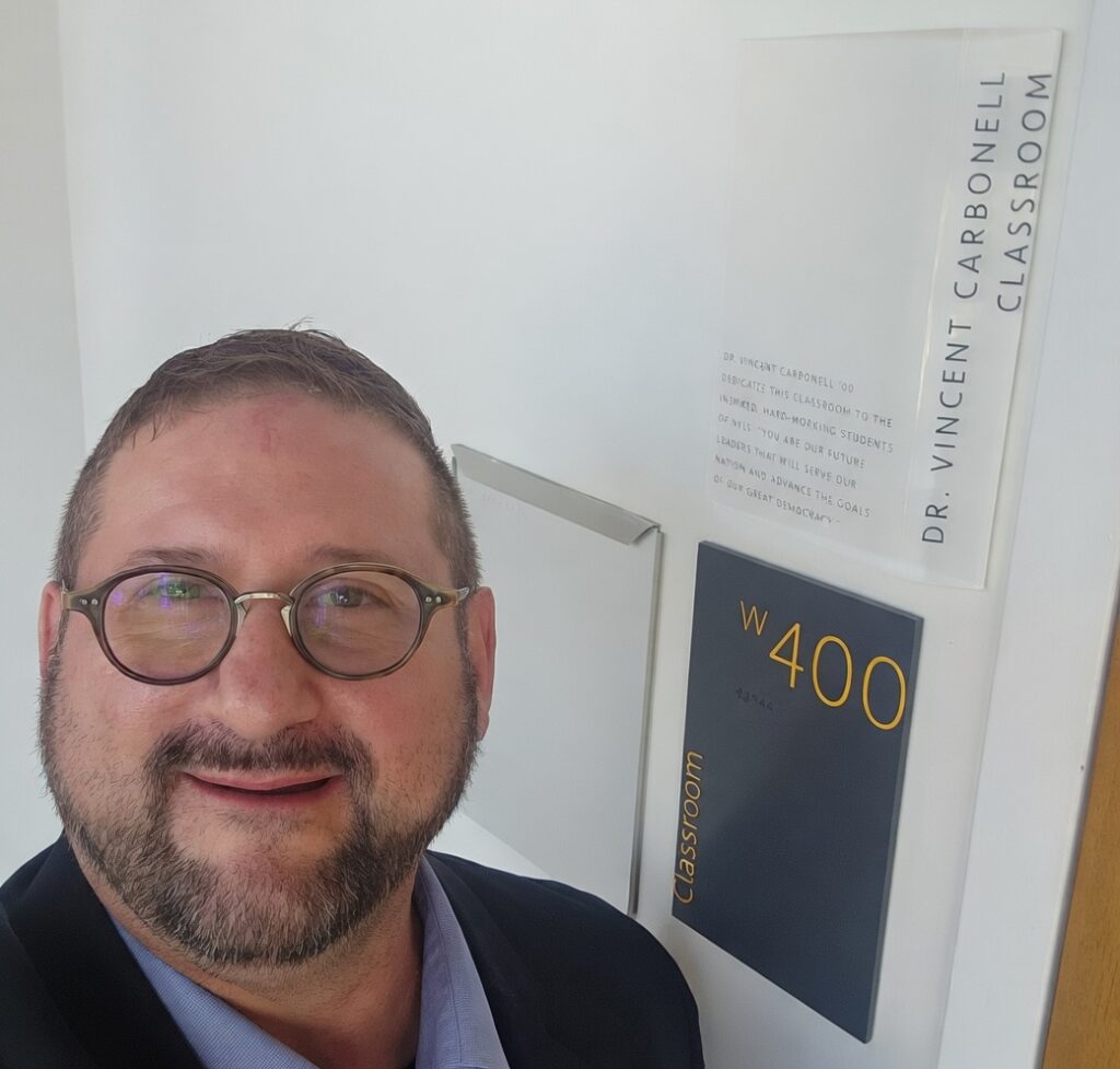 Richard Luthmann outside the Dr. Vincent Carbonell Classroom at New York Law School.